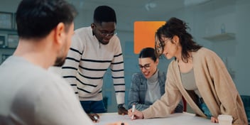 Équipe multidisciplinaire réunie autour d'une table pour planifier et améliorer des processus de travail dans le cadre d'une initiative de gestion des services d'entreprise (ESM).